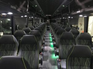 TCS Canada charter bus rental interior - black charter bus seats with green accents and lighting along the aisle way