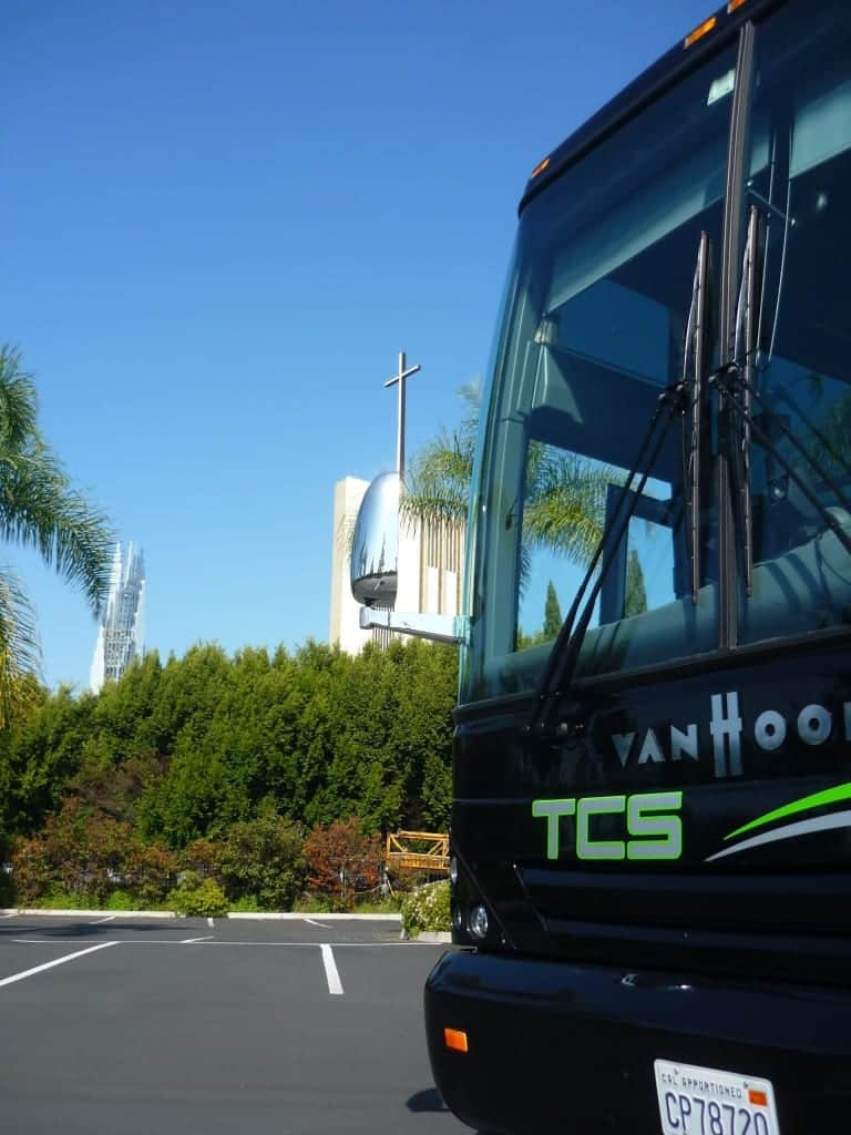 black tcs charter bus in front of church