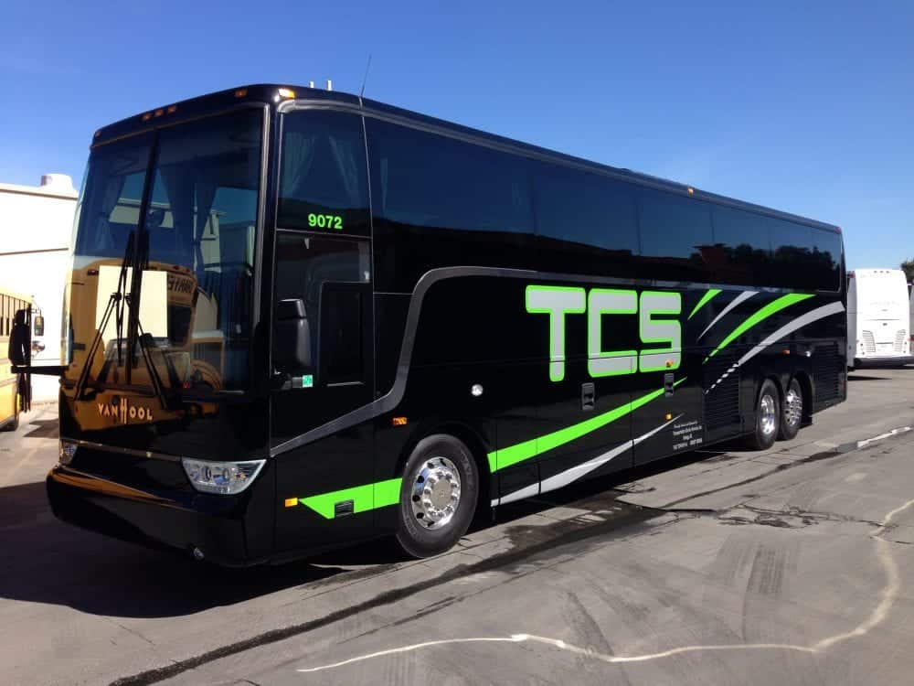 shiny black tcs canada bus in parking lot on sunny afternoon
