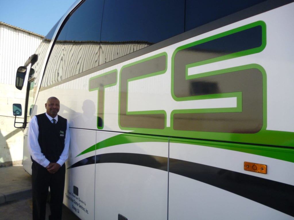 tcs canada charter bus driver standing in front of tcs branded charter bus